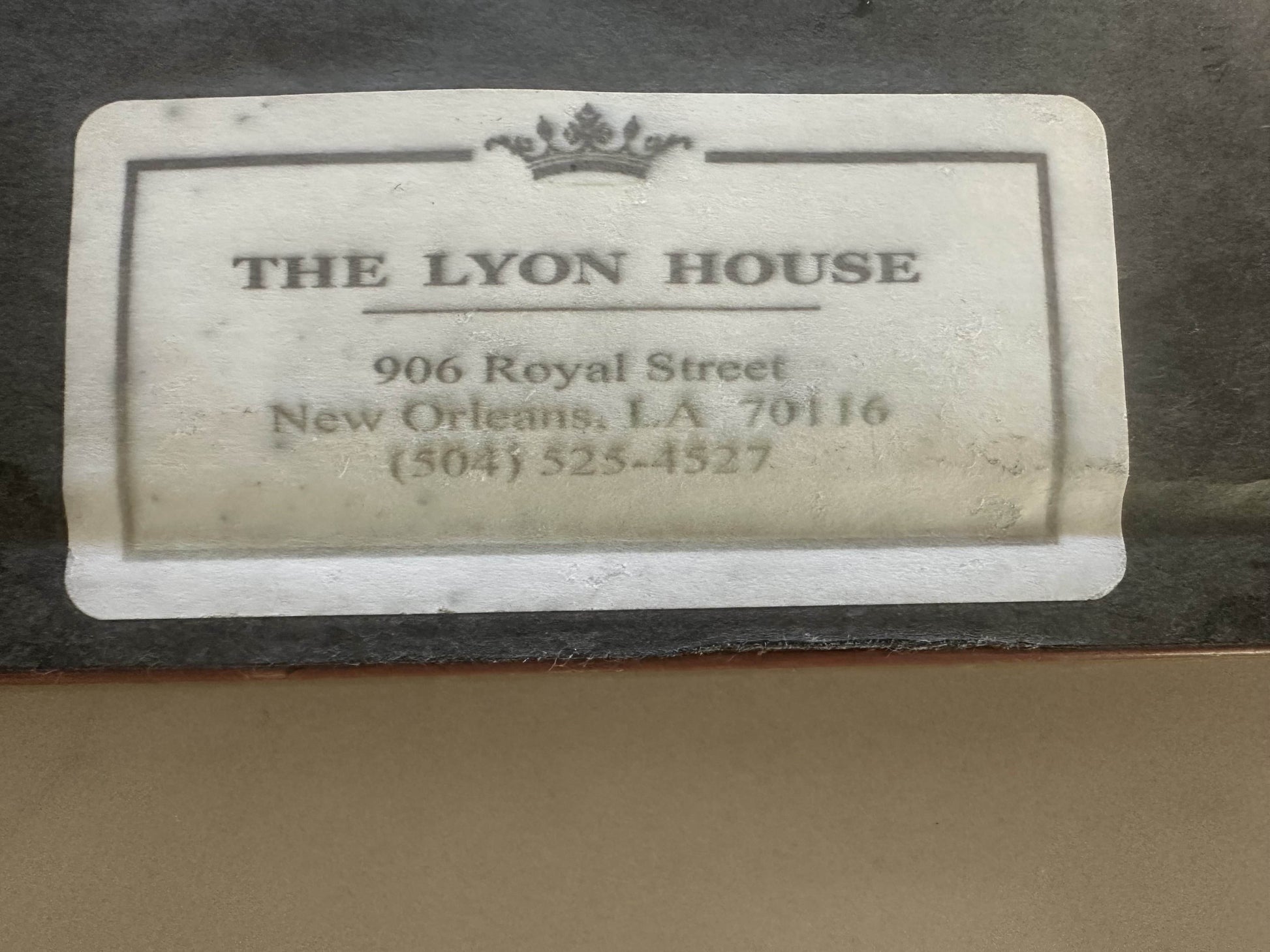 Label for 'The Lyon House' with contact information on a textured surface