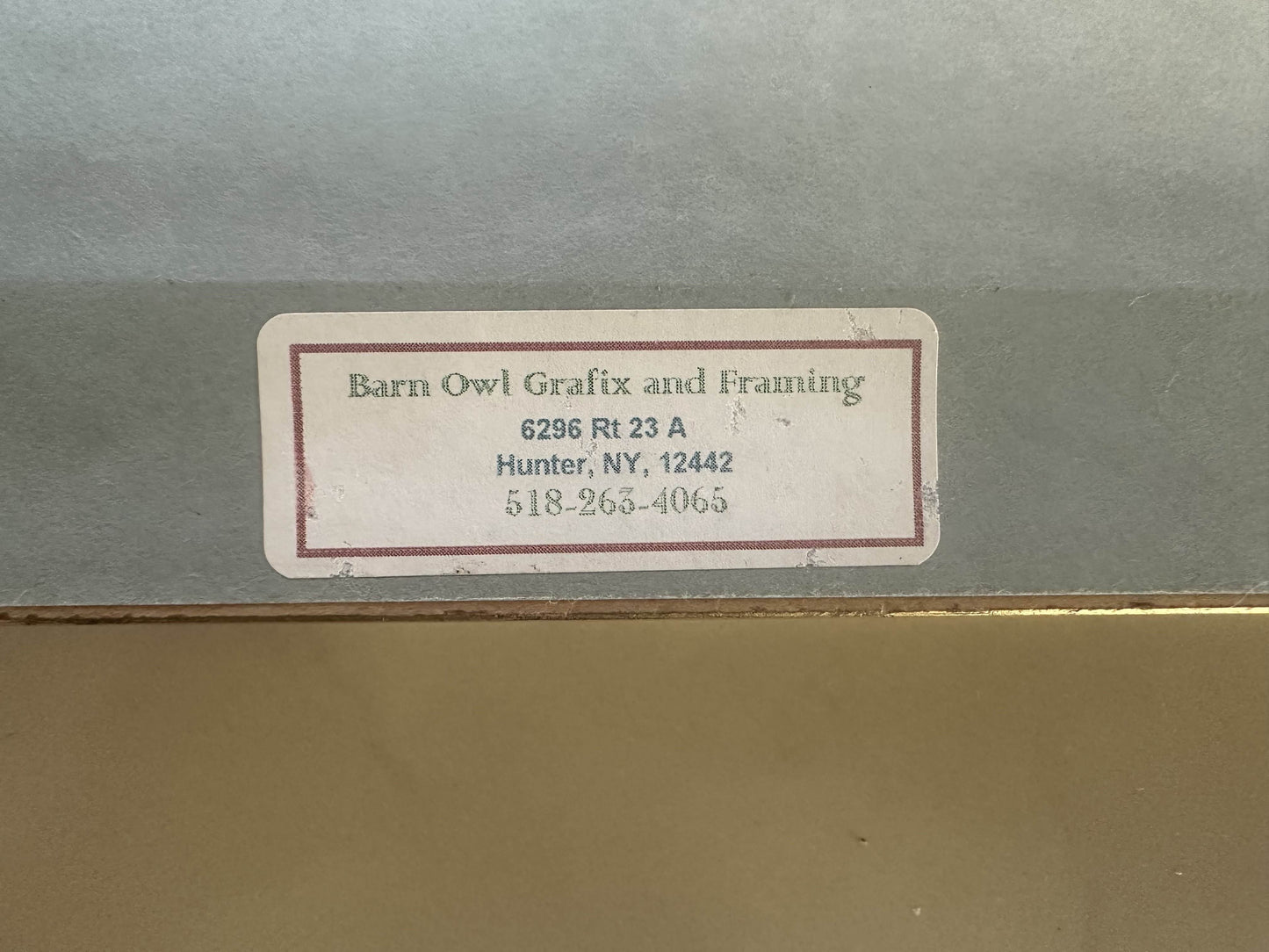 Label on a gray surface with text and contact information.