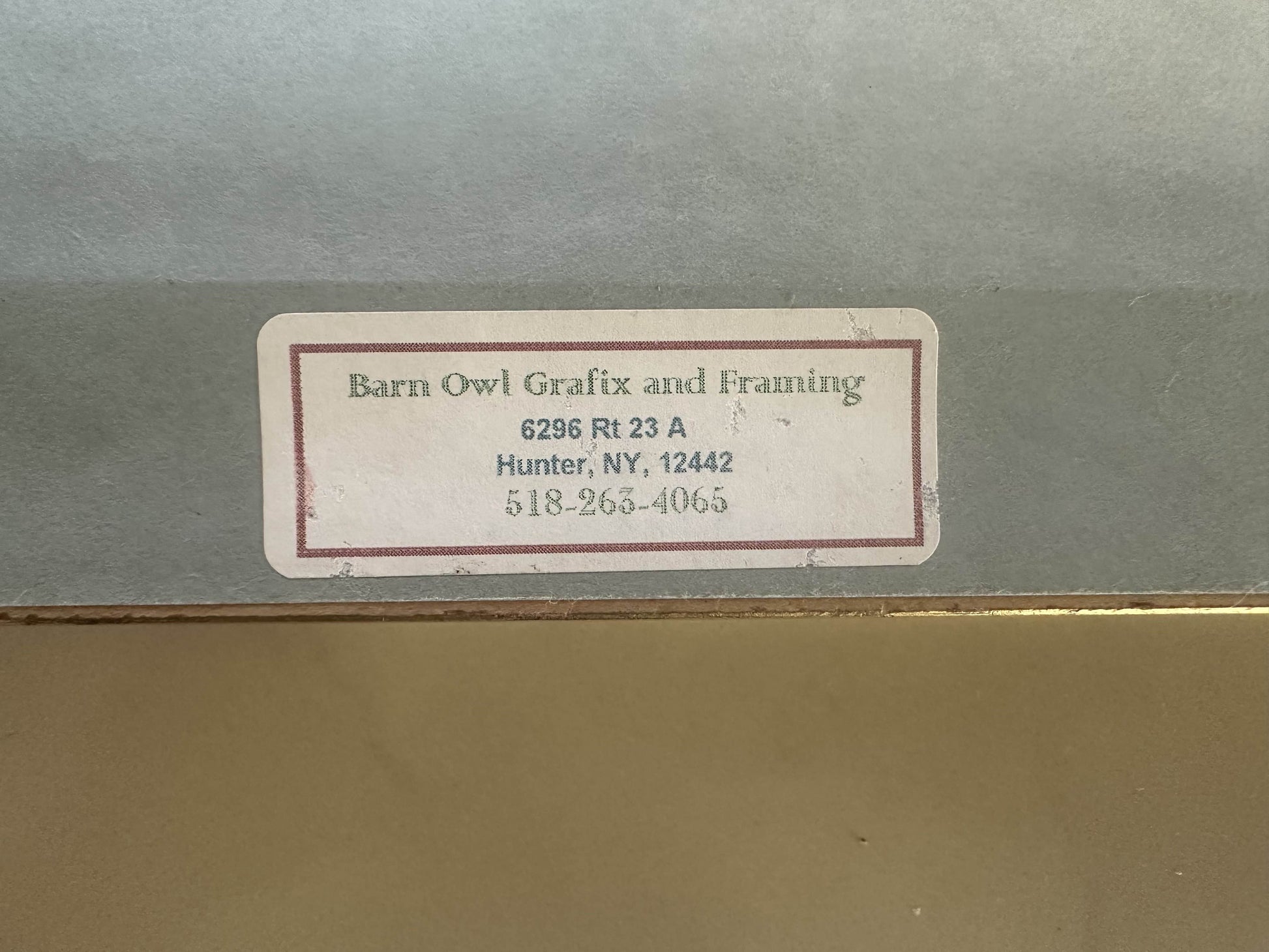 Label on a gray surface with text and contact information.